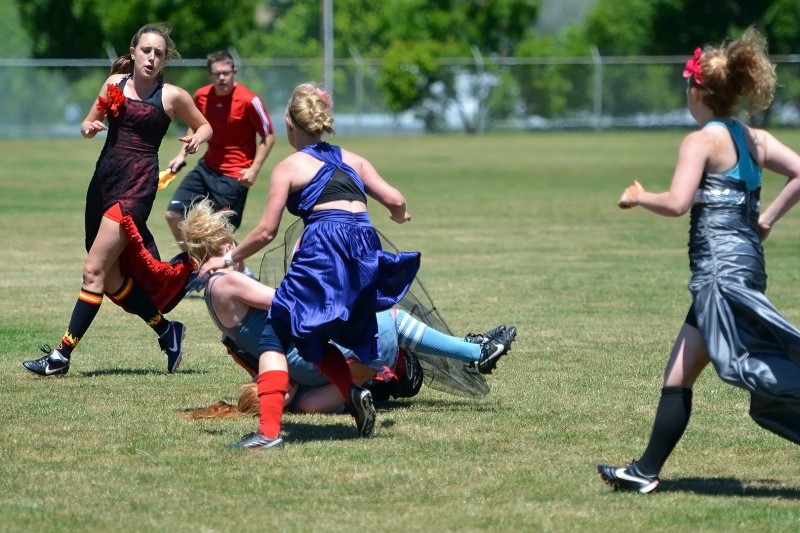 girls in prom dresses playing rugby football